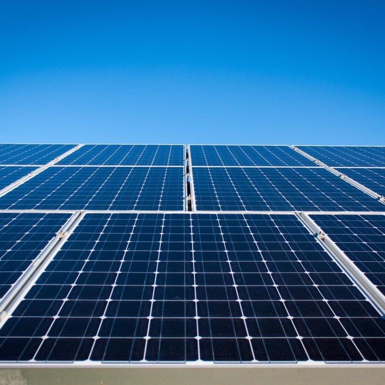 Solarmodule Reihe von Photovoltaik-Solarmodulen auf einer Fläche installiert, aufgenommen bei klarem Himmel.